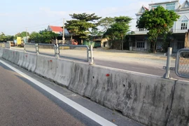 Rất nhiều tấm lưới chống lóa tuyến Quốc lộ 1A bị tháo dỡ, chỉ còn trơ lại dải phân cách. (Ảnh: Phan Quân/TTXVN)
