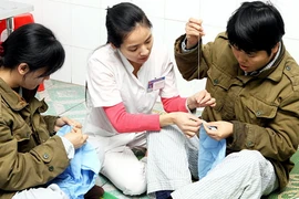 Nhân viên y tế luyện tập phục hồi chức năng cho bệnh nhân. (Ảnh: Dương Ngọc/TTXVN) 