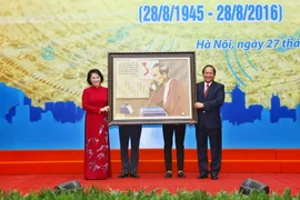 Bộ trưởng Bộ Thông tin và Truyền thông Trương Minh Tuấn tặng bức ảnh Bác Hồ cho Chủ tịch Quốc hội Nguyễn Thị Kim Ngân. (Ảnh: Minh Quyết/TTXVN) 