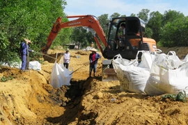 Cất bốc chất thải của công ty Formosa, chôn lấp trái phép, lên ôtô để chuyển về tạm giữ tại kho của Công ty trách nhiệm hữu hạn một thành viên Chế biến chất thải công nghiệp Hà Tĩnh. (Ảnh: Phan Quân/TTXVN) 