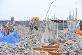 Công nhân tiến hành khoan, phá dỡ phần công trình xây dựng trái phép ở toà nhà số 8B Lê Trưc, Hà Nội, sáng 6/3. (Ảnh: Minh Đức/TTXVN)