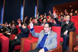 Các đại biểu biểu quyết thông qua kết quả bầu Ban Chấp hành Trung ương Đảng khóa XII. (Ảnh: TTXVN)