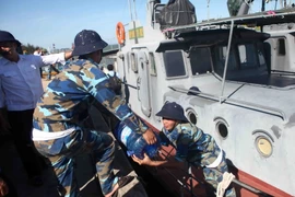 Vận chuyển nước lên tàu HQ211 để tiếp tế ra cho lực lượng tìm kiếm trên biển. (Ảnh: Thanh Tùng/TTXVN)