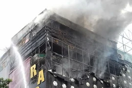 Tầng 3 quán karaoke bốc cháy nghi ngút. (Ảnh: Nguyễn Văn Trình/Vietnam+)