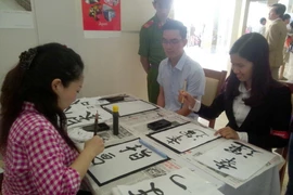 Các bạn trẻ Việt Nam trải nghiệm viết thư pháp Nhật Bản. (Ảnh minh họa: Đồng Thúy/TTXVN) 