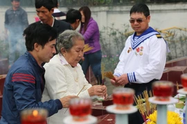Mẹ Hồ Thị Đức, mẹ của liệt sỹ Trần Văn Phương cùng đồng đội của con trai dâng hương tại lễ tri ân. (Ảnh: Mạnh Thành/TTXVN)