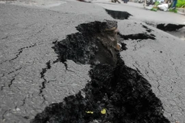 Mặt đường bị nứt toác lộ rãnh sâu kéo dài. (Ảnh: Mạnh Linh/TTXVN) 