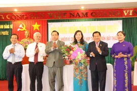 Huỳnh Thị Hằng (đứng giữa) nhận hoa chúc mừng của lãnh đạo tỉnh Bình Phước. (Ảnh: Nguyễn Văn Việt/TTXVN)