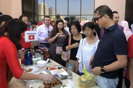 Khách tham quan và thưởng thức ẩm thực Việt Nam tại Hội chợ Từ thiện Quốc tế Bazaar 2019. (Ảnh: Việt Khoa/TTXVN)