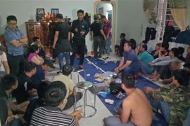 Các đối tượng tham gia đánh bạc bị bắt giữ. (Ảnh: TTXVN phát)