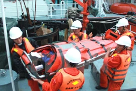 Đưa ngư dân ở vùng biển Trường Sa bị đau ruột thừa vào bờ điều trị. (Ảnh: Nguyên Lý/TTXVN) 