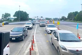 Xe xếp hàng dài lưu thông qua trạm thu phí tự động không dừng trên tuyến đường Cao tốc Nội Bài-Lào Cai. (Ảnh: PV/Vietnam+)
