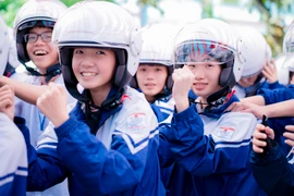 Đội mũ bảo hiểm đạt chuẩn giúp các em học sinh hạn chế thương tích khi tham gia giao thông. (Ảnh: PV/Vietnam+)