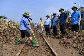 Nhân viên đường sắt dọn dẹp bùn trong khu vực ray tàu hỏa để thông tuyến, chạy tàu trở lại. (Ảnh: PV/Vietnam+)