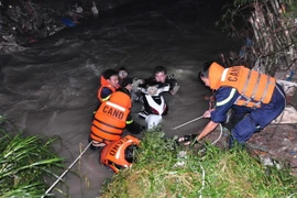 Lực lượng cứu hộ, cứu nạn tỉnh Đồng Nai đưa chiếc xe máy lên bờ và tiếp tục tham gia tìm kiếm người đàn ông mất tích do lũ cuốn trôi trong đêm. (Ảnh: Sỹ Tuyên/TTXVN)