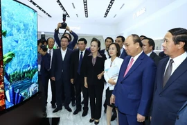 Thủ tướng Nguyễn Xuân Phúc xem các sản phẩm của Công ty LG Display Việt Nam Hải Phòng. (Ảnh: Thống Nhất/TTXVN)