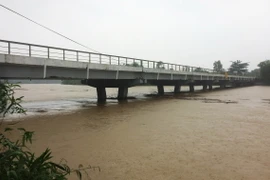 Cầu Phước Tích trên tỉnh lộ 49, huyện Phong Điền, tỉnh Thừa Thiên-Huế nước lũ dân cao gần chạm đáy cầu. (Ảnh: Hồ Cầu/TTXVN)