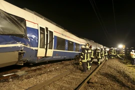 Lực lượng cứu hộ làm nhiệm vụ tại hiện trường vụ tai nạn. (Nguồn: AFP/TTXVN)