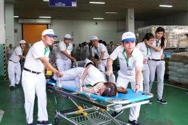 Diễn tập tình huống công nhân bị ngộ độc thực phẩm sau buổi ăn trưa. (Ảnh: Phương Vy/TTXVN)