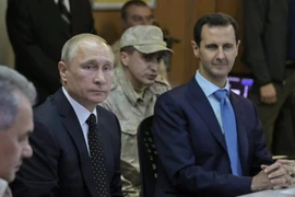 Tổng thống Nga Vladimir Putin (trái) và Tổng thống Syria Bashar al-Assad (phải) trong cuộc họp tại căn cứ quân sự Hmeimim ở Latakia, Syria ngày 11/12. (Nguồn: AFP/TTXVN)