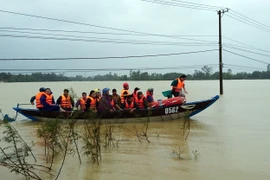 Lực lượng Công an tỉnh Quảng Nam giúp dân di chuyển ra khỏi vùng ngập lụt tại xã Tam Đàn, huyện Phú Ninh, Quảng Nam. (Ảnh: Nguyễn Sơn/TTXVN)
