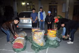 Các đối tượng (đứng giữa) và tang vật vụ án bắt giữ pháo lậu ở Hải Dương. (Ảnh: Mạnh Tú/TTXVN)