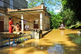 Nước ngập sâu nên người dân tại thôn Kiến Phong, xã Gia Tường, huyện Nho Quan phải di chuyển bằng thuyền. (Ảnh: Minh Đức/TTXVN)