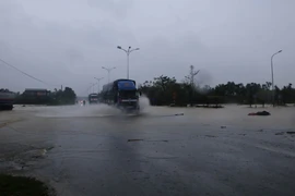 Nước lụt dâng ngập Quốc lộ 1A tại km808, thuộc địa phượng thị xã Hương Trà. (Ảnh: Hồ Cầu/TTXVN)