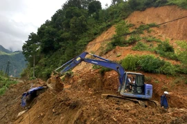 Nhiều phương tiện được huy động tham gia san gạt đất, đá, nhưng đến nay ôtô vẫn chưa thể đi vào huyện Trạm Tấu. (Ảnh: Trung Kiên/TTXVN)