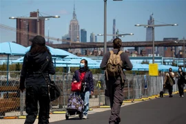 Người dân đeo khẩu trang phòng dịch COVID-19 khi đi dạo trong công viên ở Brooklyn, New York, Mỹ. (Ảnh: THX/TTXVN)