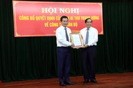 Phó Trưởng ban Thường trực Ban Tổ chức Trung ương Nguyễn Thanh Bình trao Quyết định của Ban Bí thư Trung ương Đảng cho ông Triệu Thế Hùng (bên trái). (Ảnh: Mạnh Tú/TTXVN)