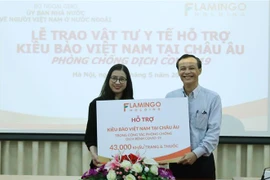 Đại diện Tập đoàn Flamingo trao tượng trưng tặng 43.000 khẩu trang và thuốc, hỗ trợ kiều bào Việt Nam ở châu Âu phòng chống dịch COVID-19. (Ảnh: Lâm Khánh/TTXVN)