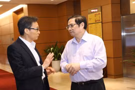 Phó Thủ tướng Vũ Đức Đam và Trưởng Ban Tổ chức Trung ương Phạm Minh Chính trao đổi bên hành lang Quốc hội. (Ảnh: Văn Điệp/TTXVN)