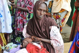 Một bà mẹ mang con bị suy dinh dưỡng tới khám tại bệnh viện ở Gao, Mali. (Ảnh: AFP/TTXVN)