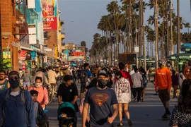 Người dân đi dạo trên bãi biển ở California, Mỹ sau khi lệnh hạn chế nhằm ngăn dịch COVID-19 lây lan được nới lỏng, ngày 22/5. (Ảnh: AFP/TTXVN)