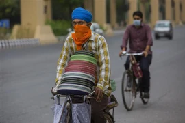 Người dân đeo khẩu trang phòng lây nhiễm COVID-19 tại New Delhi, Ấn Độ. (Ảnh: THX/TTXVN)