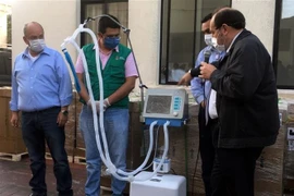 Bộ trưởng Y tế Bolivia Marcelo Navajas (phải) trong lễ bàn giao các máy trợ thở tại một bệnh viện ở Santa Cruz, Bolivia ngày 19/5. (Ảnh: AFP/TTXVN)