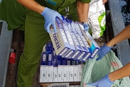 Lực lượng chức năng kiểm đếm số tang vật một vụ vận chuyển trái phép thuốc lá. (Ảnh: Công Mạo/TTXVN)