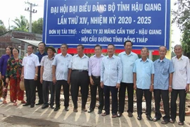Lãnh đạo tỉnh Hậu Giang, huyện Vị Thủy, huyện Phụng Hiệp và người dân địa phương chụp ảnh lưu niệm. (Ảnh: Hồng Thái/TTXVN)