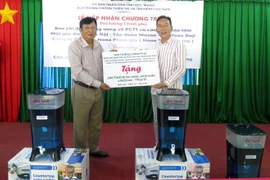 Giám đốc Sở Nông nghiệp và Phát triển nông thôn tỉnh Sóc Trăng Lương Minh Quyết tiếp nhận thiết bị lọc, xử lí nước LifeStraw từ các nhà tài trợ. (Ảnh: Trung Hiếu/TTXVN)