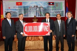 Đại sứ Nguyễn Mạnh Hùng trao quà tặng 40 tỷ đồng của Chủ tịch nước Trương Tấn Sang để xây dựng Nhà Văn hóa của tỉnh Luang Prabang. (Ảnh: Phạm Kiên/Vietnam+)