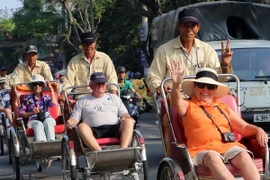 Du khách Pháp đi xích lô tham quan thành phố Đà Nẵng. (Ảnh: Trần Lê Lâm/TTXVN)