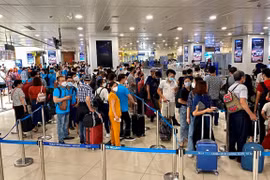 Hành khách làm thủ tục soi chiếu trước khi lên máy bay tại Cảng hàng không quốc tế Nội Bài. (Ảnh: CTV/Vietnam+)