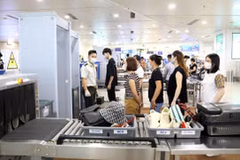 Nhân viên an ninh hàng không thực hiện quy trình soi chiếu an ninh. (Ảnh: CTV/Vietnam+)