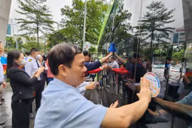 Các đại biểu dán các khẩu hiệu tuyên truyền trên xe buýt điện nhằm ủng hộ Tuần lễ An toàn giao thông đường bộ toàn cầu lần thứ 7. (Ảnh: Việt Hùng/Vietnam+)
