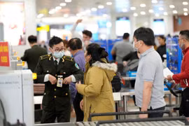Hành khách làm thủ tục an ninh tại sân bay Nội Bài. (Ảnh: CTV/Vietnam+)