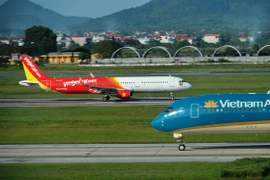 Máy bay của hai hãng hàng không Vietnam Airlines và Vietjet đang chuẩn bị cất, hạ cánh tại một sân bay. (Ảnh: PV/Vietnam+)