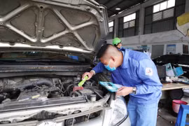 Nhân viên đăng kiểm thực hiện quy trình kiểm định xe cơ giới. (Ảnh: Minh Hiếu/Vietnam+)