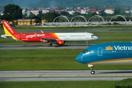 Máy bay của hai hãng hàng không Vietnam Airlines và Vietjet đang chuẩn bị cất, hạ cánh tại một sân bay. (Ảnh: PV/Vietnam+)