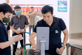 Hành khách làm thủ tục đi máy bay bằng ứng dụng tài khoản định danh điện tử. (Ảnh: PV/Vietnam+)
